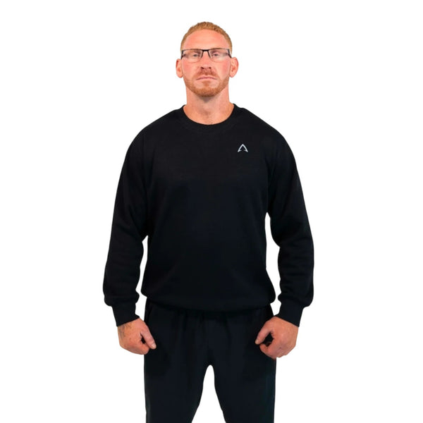 I AM FITNESS APPAREL black crewneck sweatshirt with small white diamond logo on chest and "Fitness Is My Life Style" graphic on back. Model wears glasses and black sweatpants.